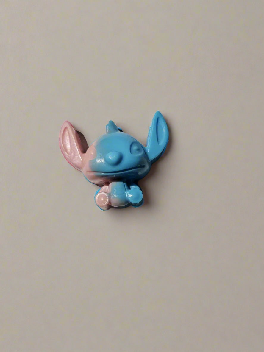 Blue and pink cartoon character on a white surface