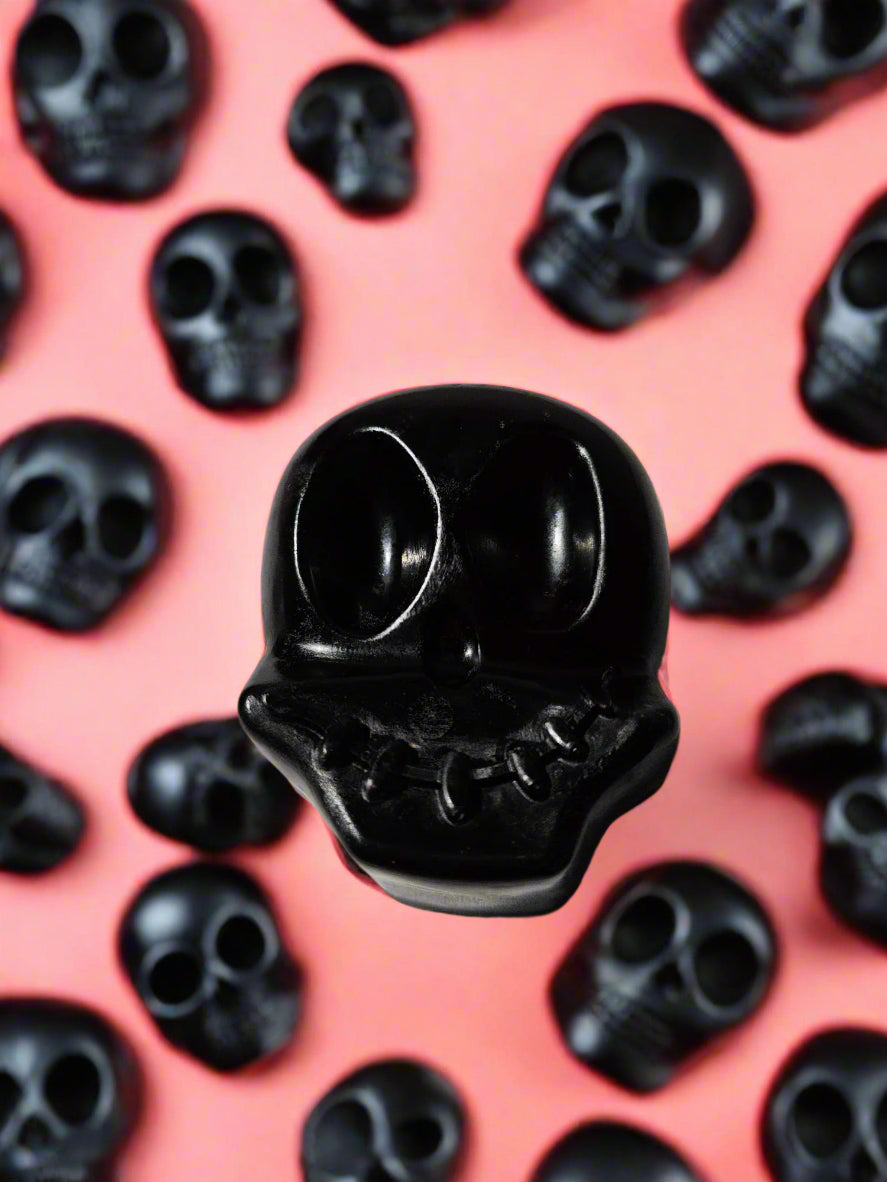 Black skull-shaped soap on a Halloween themed background background