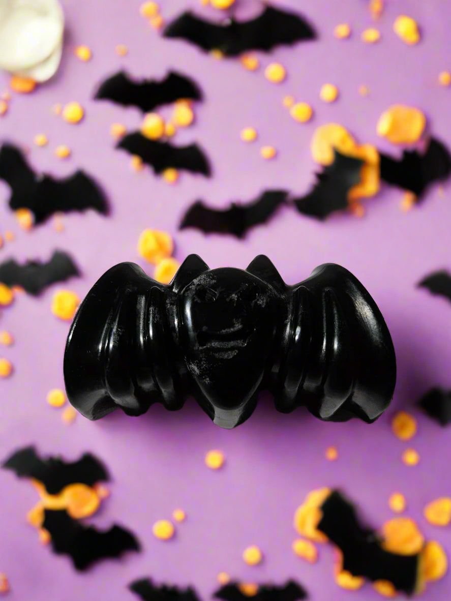 Black bat-shaped soap on a Halloween themed background