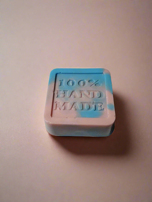 Bar of soap with '100% Hand Made' text on a light background